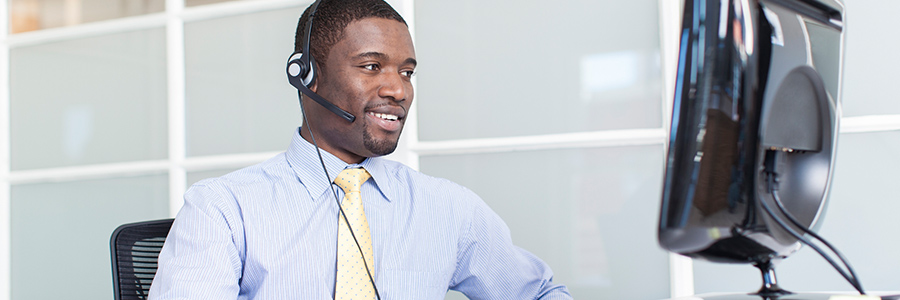 IT help desk employee smiling as they talk to a customer on the phone