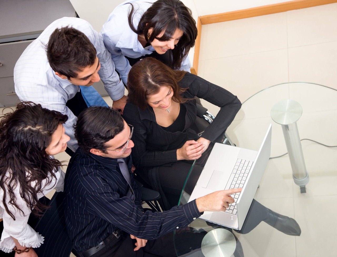 A business team all looking at a computer screen in an office